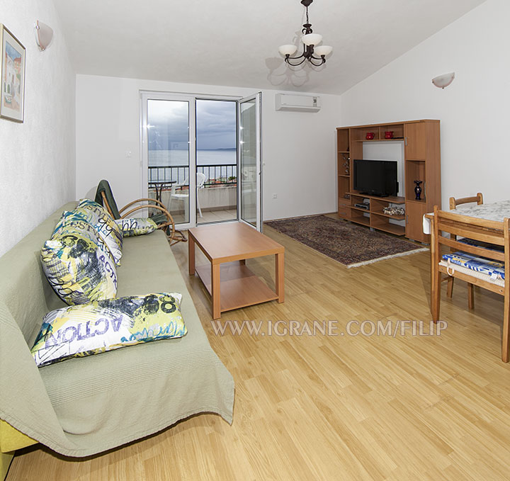 living room with sofa as additional bed, sea view, LCD TV
